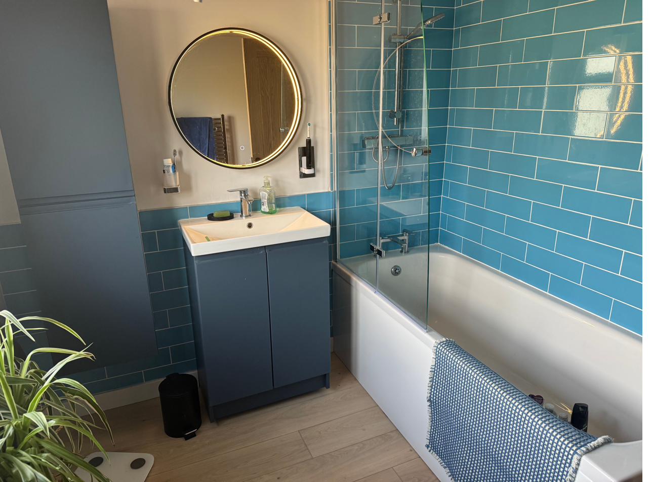New bathroom with blue metro tiles installed as part of a dormer conversion