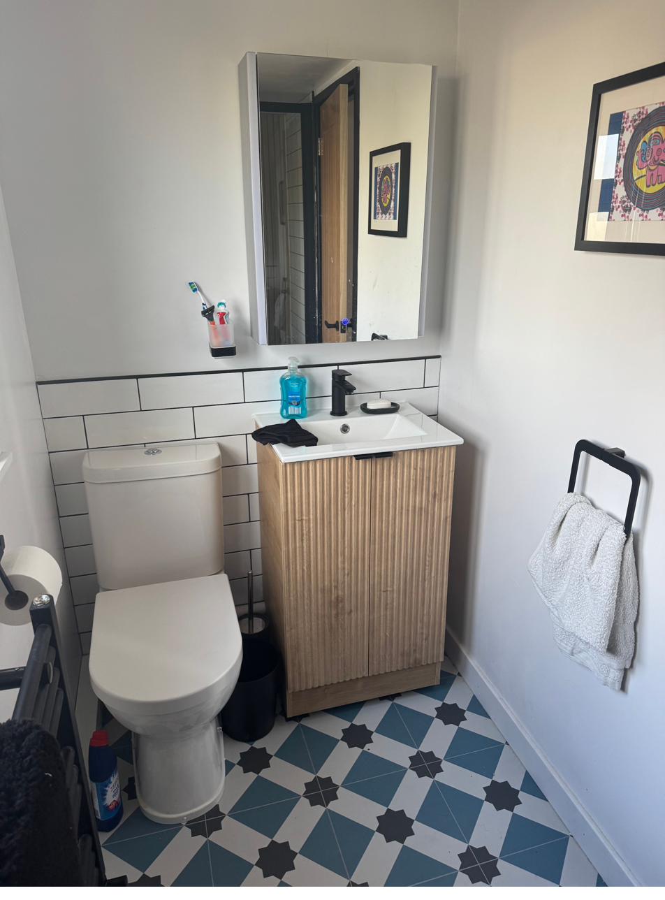 New en-suite with patterned floor tiles and timber vanity unit