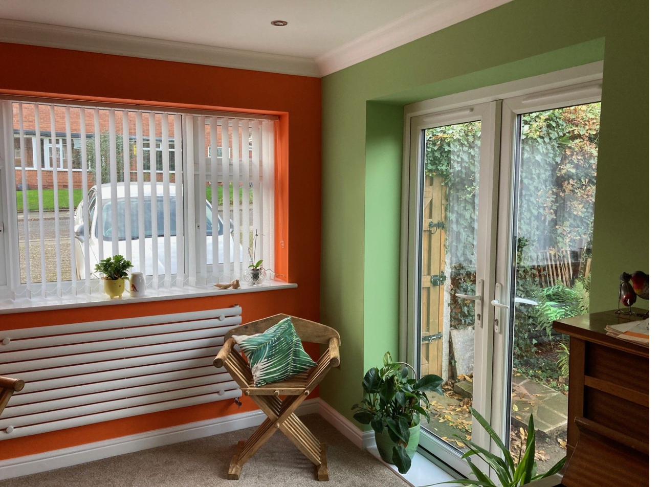 Finished room with orange and green feature walls and new patio doors