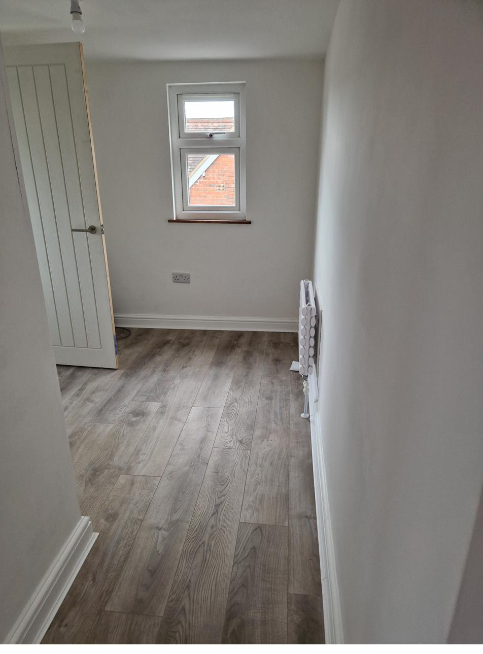 New landing area with grey wood-effect flooring and roof window