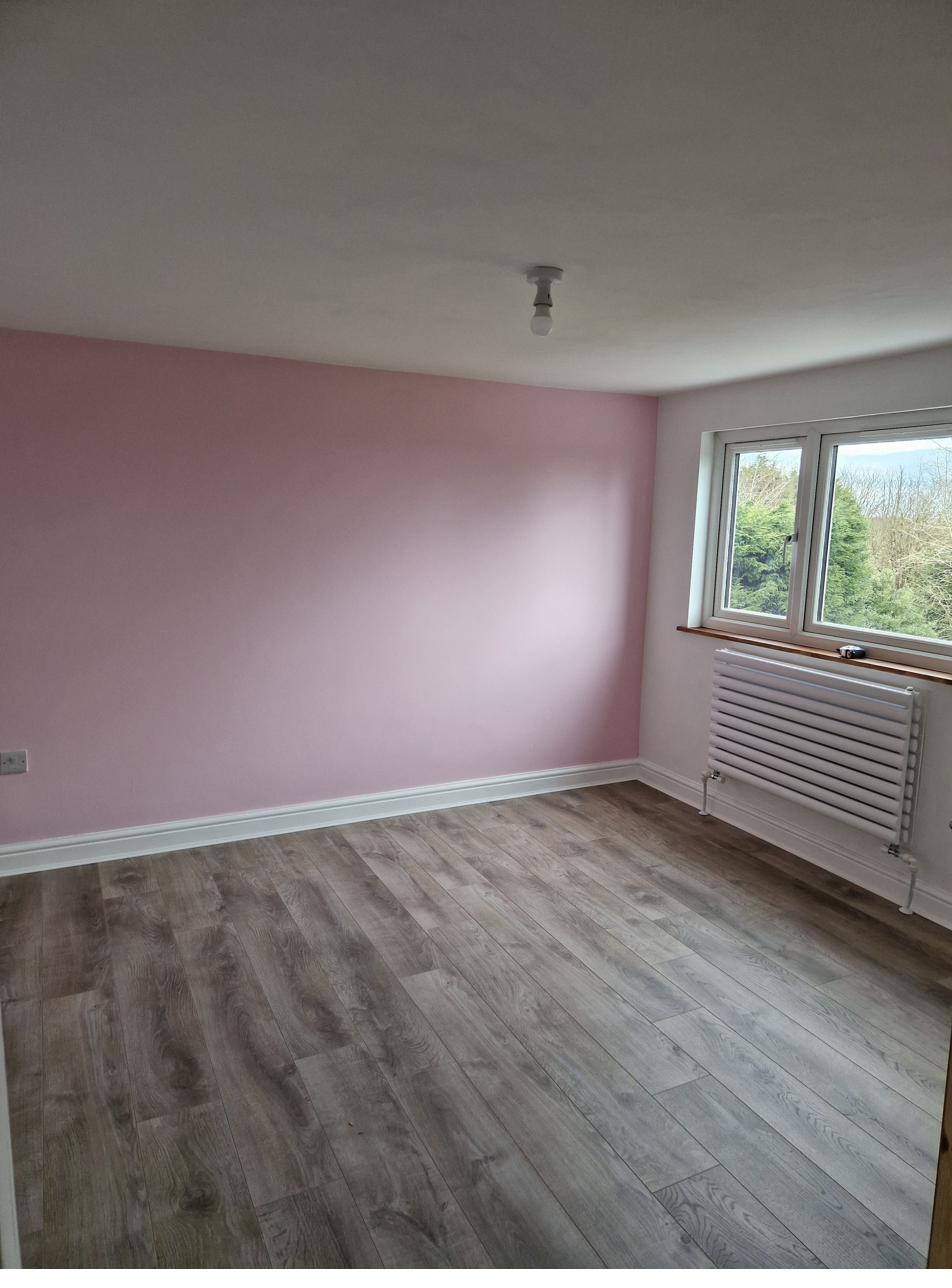 New bedroom with pink feature wall and grey flooring
