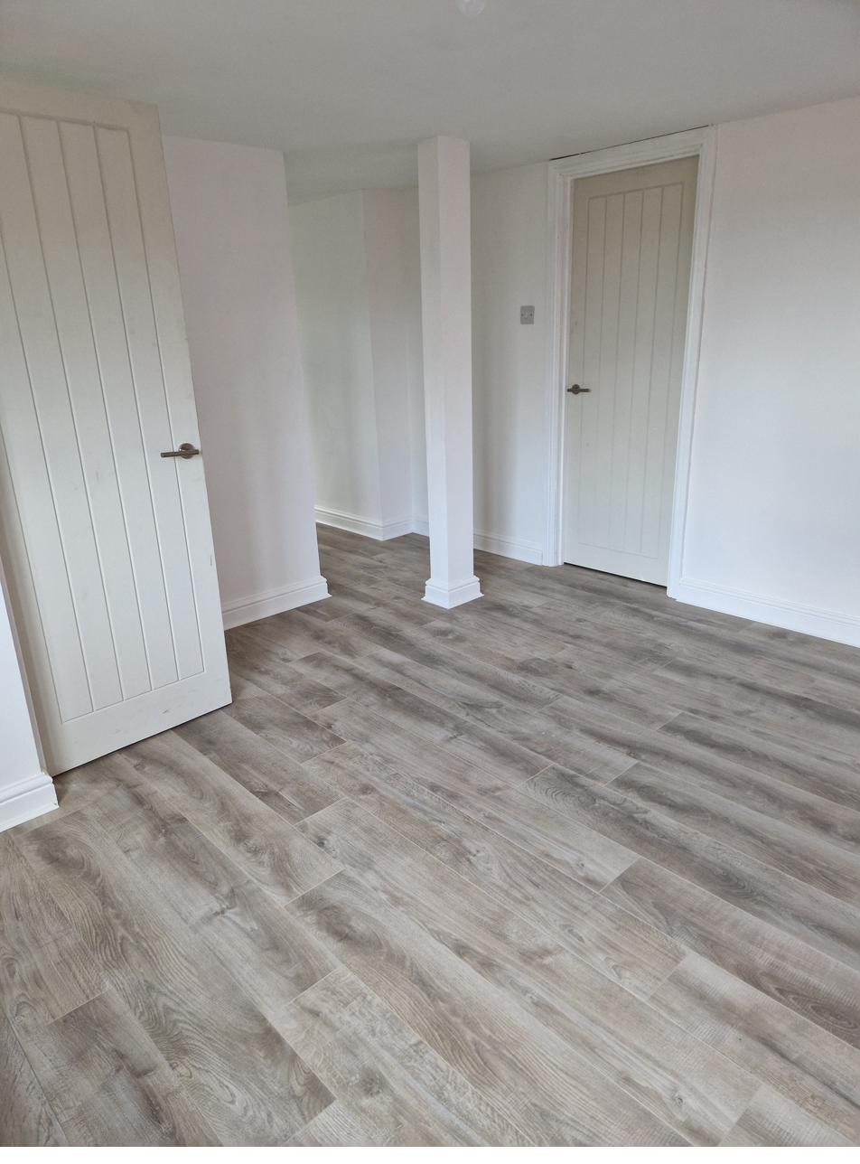New loft room with grey wood-effect flooring